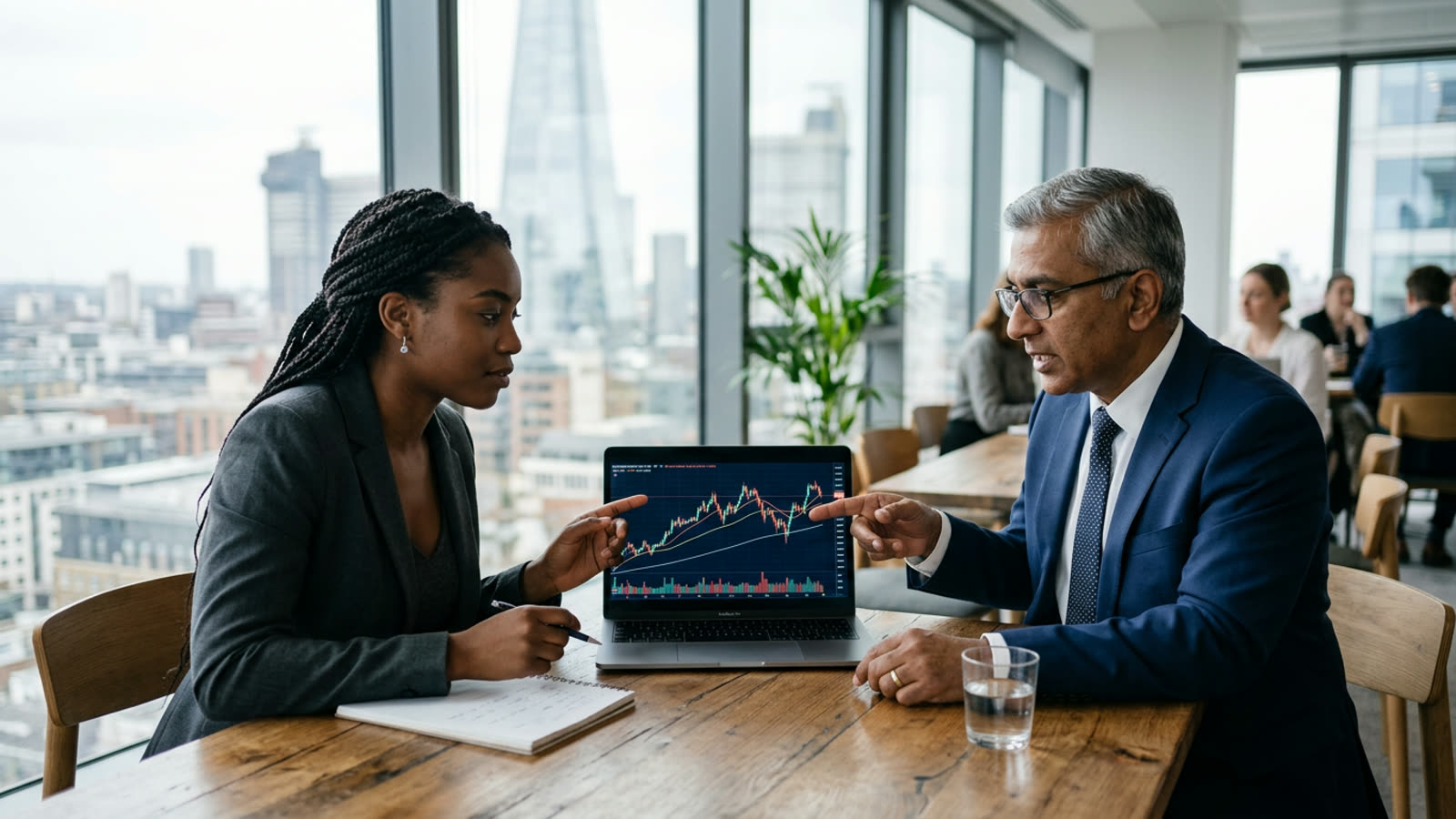 A tech employee reviewing a single company stock chart on a laptop with a financial advisor