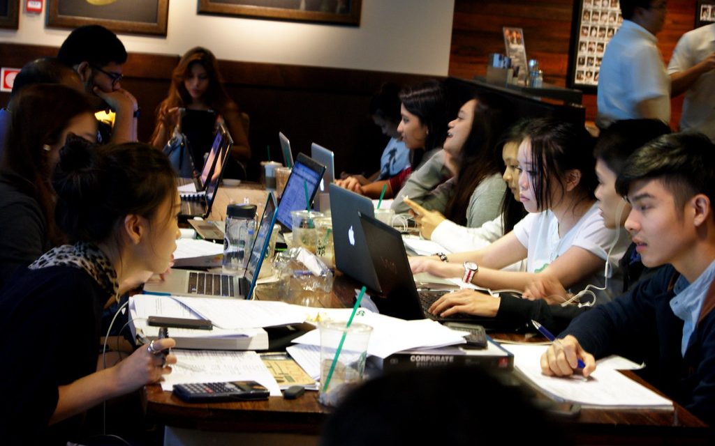 Students studying on laptops at a cafe table