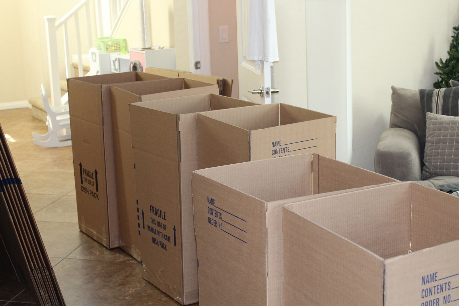 Packed cardboard moving boxes lined up in a living room.