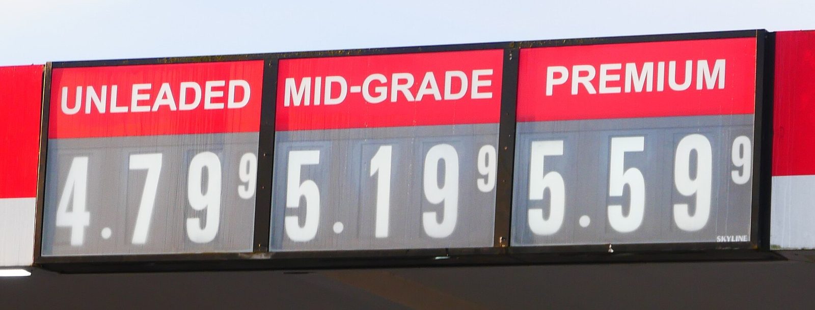 A gas station sign lists unleaded, mid-grade and premium prices.