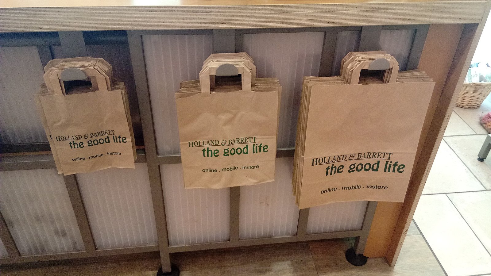 Three paper shopping bags lined up on a store counter.