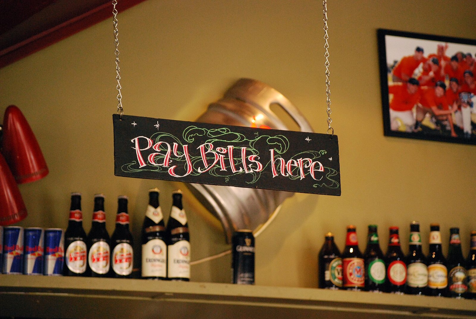 A hand-lettered "Pay Bills Here" sign hanging above a shop counter.