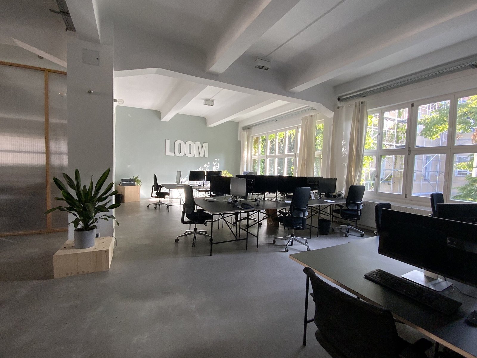 An empty open-plan office with unoccupied desks and chairs.
