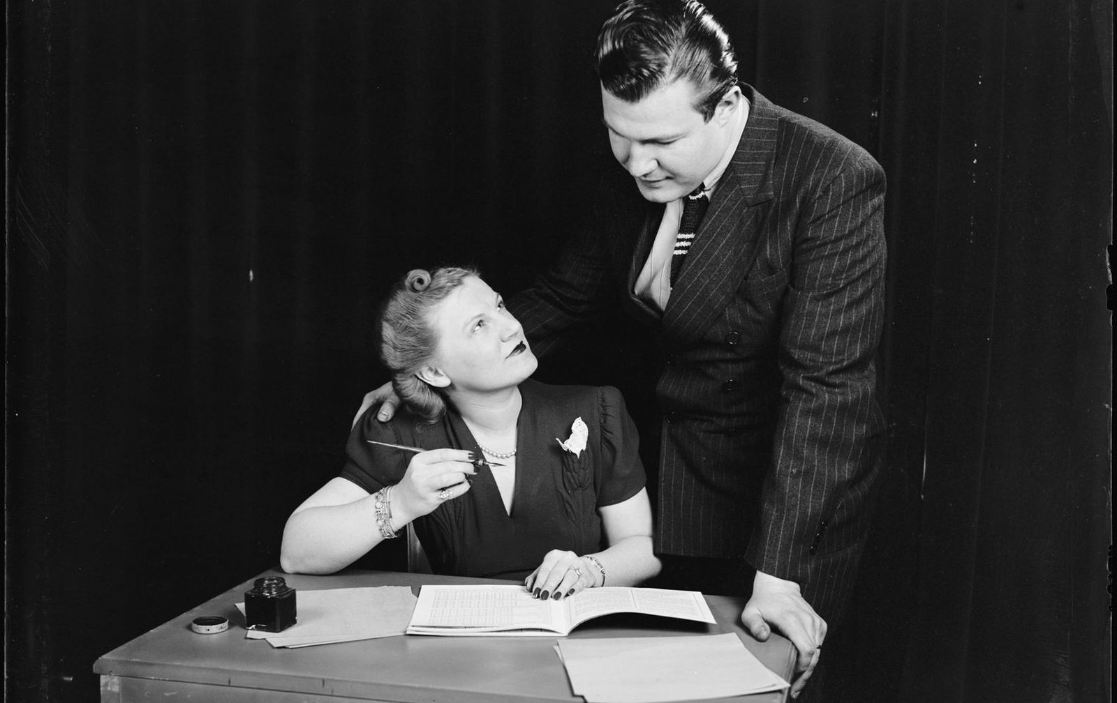 A couple at a desk going over their household budget together, 1940s.