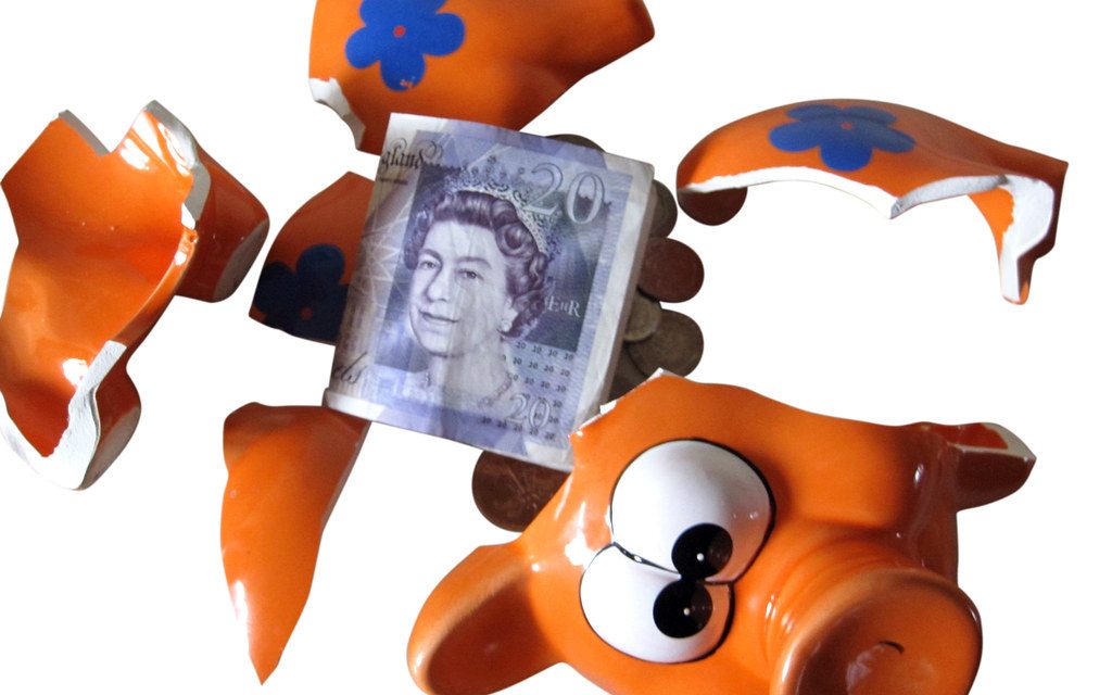 A smashed piggy bank with banknotes inside