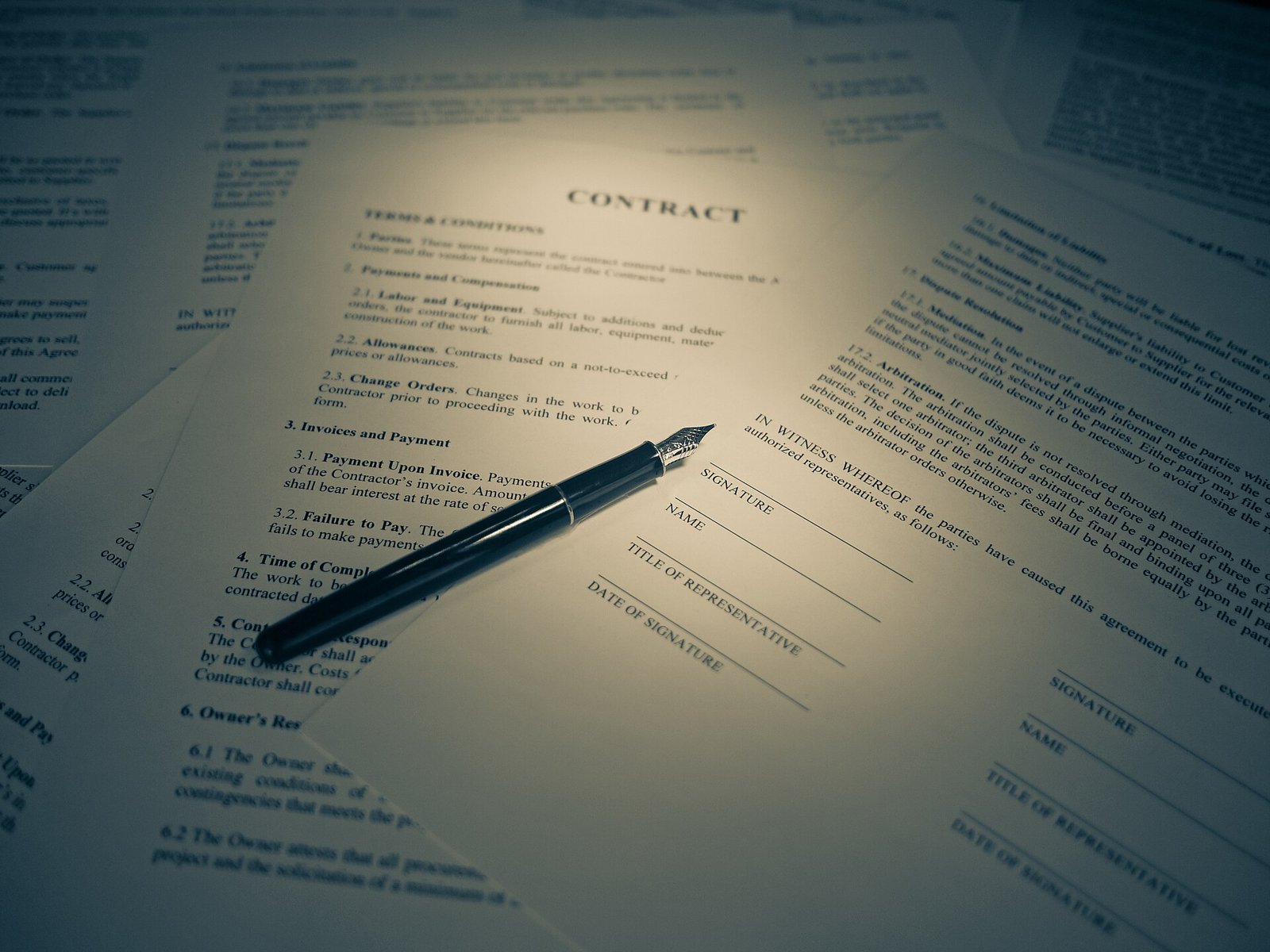 A fountain pen resting on a printed legal contract.
