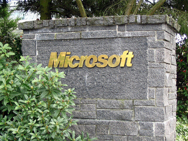 The Microsoft name in gold letters on a stone sign at an entrance to Microsoft's headquarters campus in Redmond, Washington