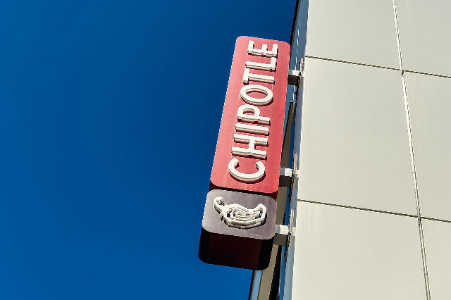 The red Chipotle sign with its chili pepper logo above a Chipotle Mexican Grill restaurant on Forbes Avenue in Pittsburgh, Pennsylvania