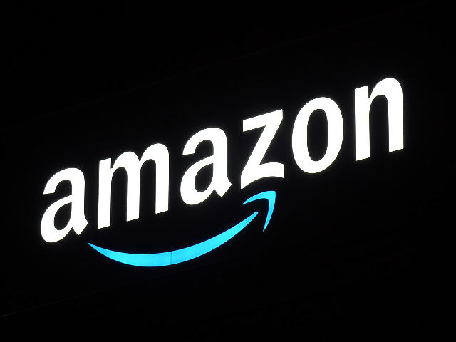 The illuminated Amazon logo on the outside of an Amazon fulfillment center in Chiba, Japan, at night